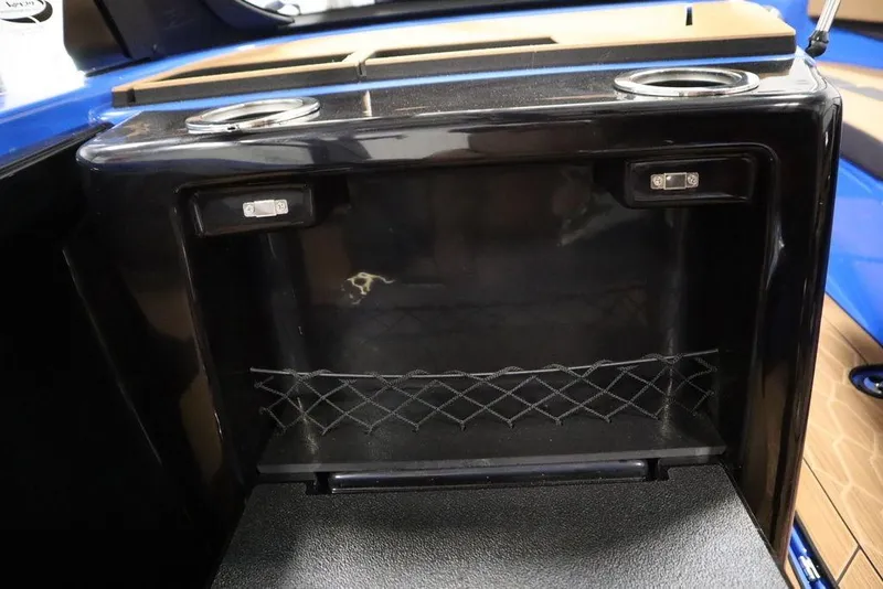 Slide: The Image of 2024 Yamaha Boats 222XE storage compartment with cup holders and netting. - 37