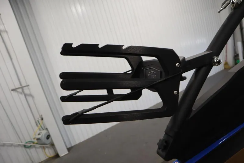 Slide: The Image of 2024 Yamaha Boats 222XE wakeboard rack, black, mounted on a boat, indoor setting. - 48