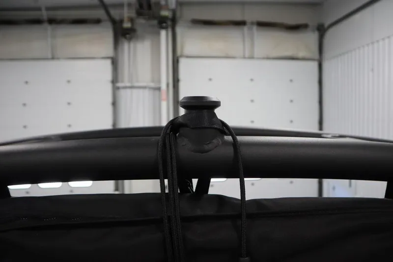 Slide: The Image of 2024 Yamaha Boats 222XE, close-up of black frame and rope detail in a garage. - 49