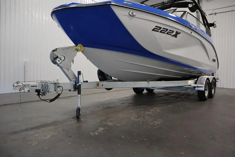 Slide: The Image of 2024 Yamaha Boats 222XE on trailer, blue and white design, in indoor setting. - 54