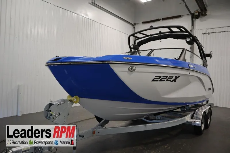 Slide: The Image of 2024 Yamaha Boats 222XE in showroom, blue and white design, on trailer. - 64