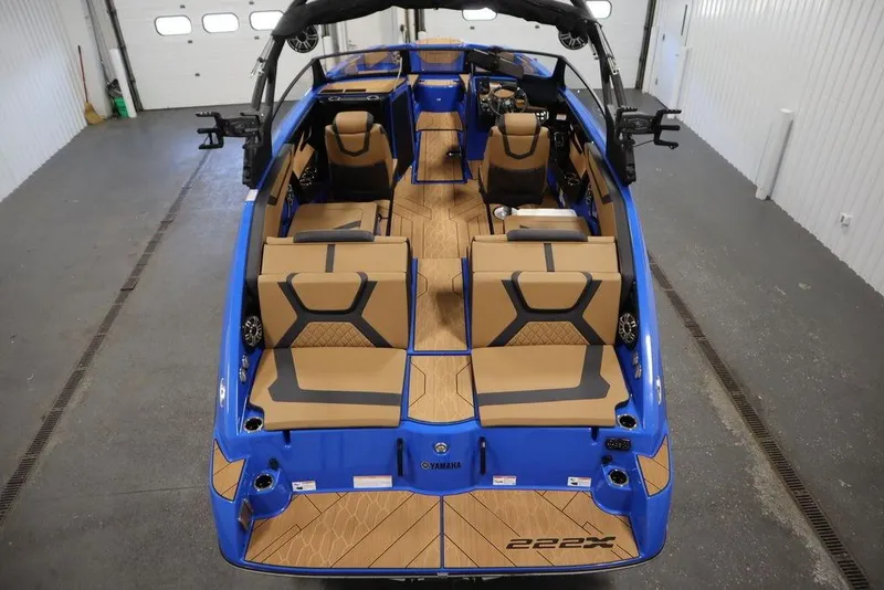 Slide: The Image of 2024 Yamaha Boats 222XE interior, featuring tan and black seating with a sleek blue exterior. - 8