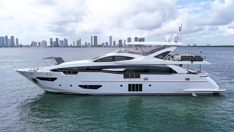 Slide: The Image of Luxury 2017 Azimut 95 Raised Pilothouse yacht on calm water with city skyline. - 11