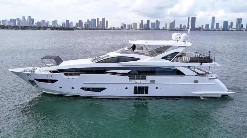 Slide: The Image of Luxury 2017 Azimut 95 Raised Pilothouse yacht on water with city skyline backdrop. - 24