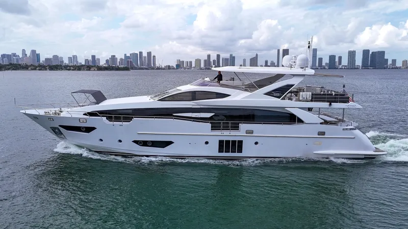 Slide: The Image of Luxury 2017 Azimut 95 Raised Pilothouse yacht cruising near city skyline. - 26