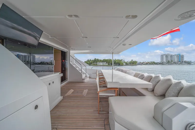 Slide: The Image of Luxurious 2017 Azimut 95 Raised Pilothouse yacht deck with seating, table, and scenic waterfront view. - 33