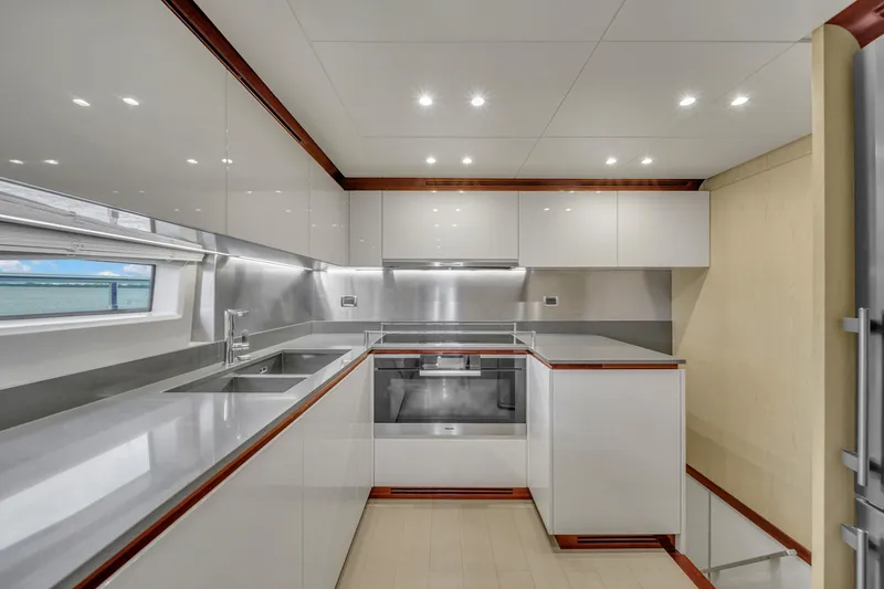 Slide: The Image of Modern kitchen interior on 2017 Azimut 95 Raised Pilothouse yacht, featuring sleek cabinetry and stainless steel appliances. - 48