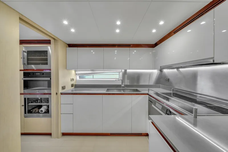 Slide: The Image of Modern kitchen interior on 2017 Azimut 95 Raised Pilothouse yacht, featuring sleek cabinetry and appliances. - 49