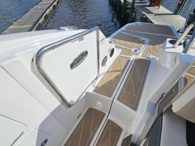 Slide: The Image of 2025 Monterey M-65 boat deck with sleek design and wood accents at a marina. - 12