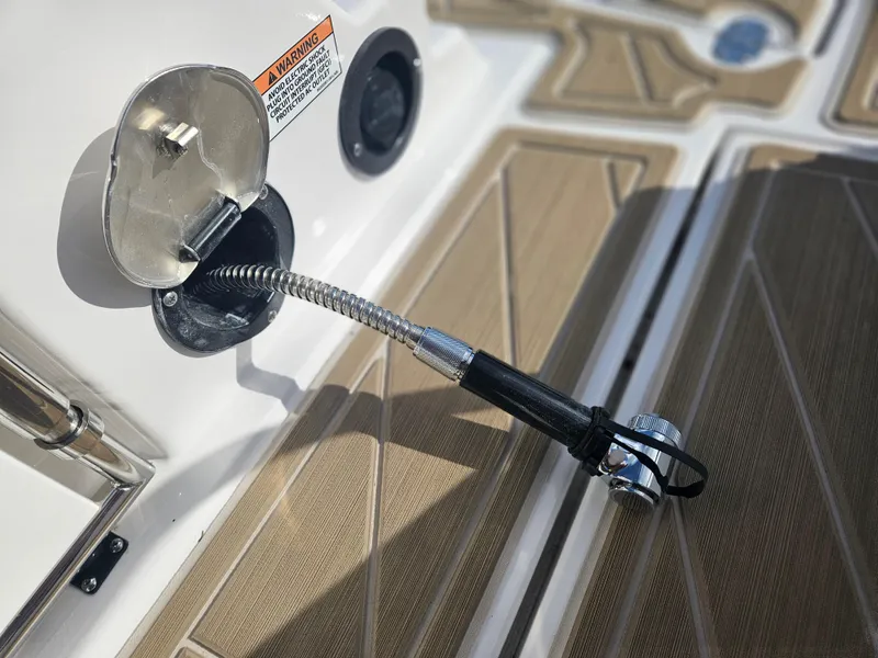 Slide: The Image of Fuel inlet on 2025 Monterey M-65 boat with flexible hose and warning label. - 13