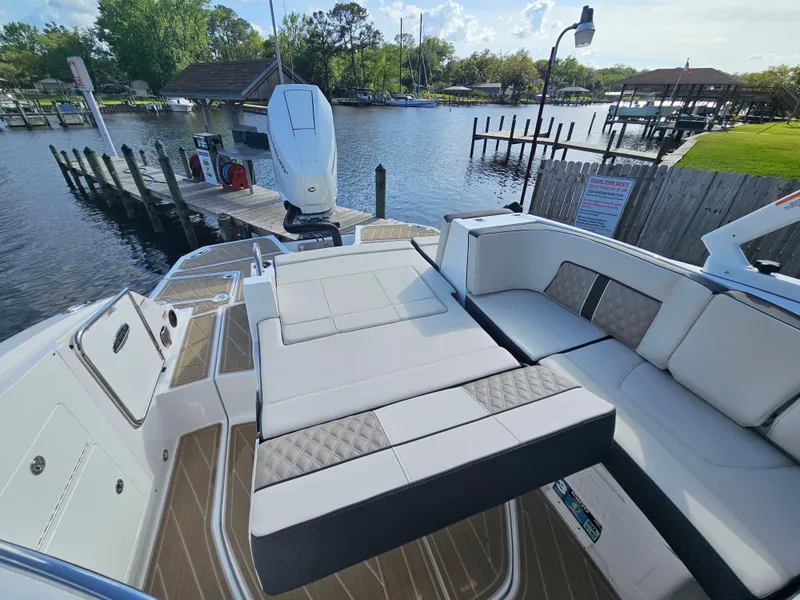 Slide: The Image of 2025 Monterey M-65 boat with spacious seating, docked by a serene waterfront. - 16