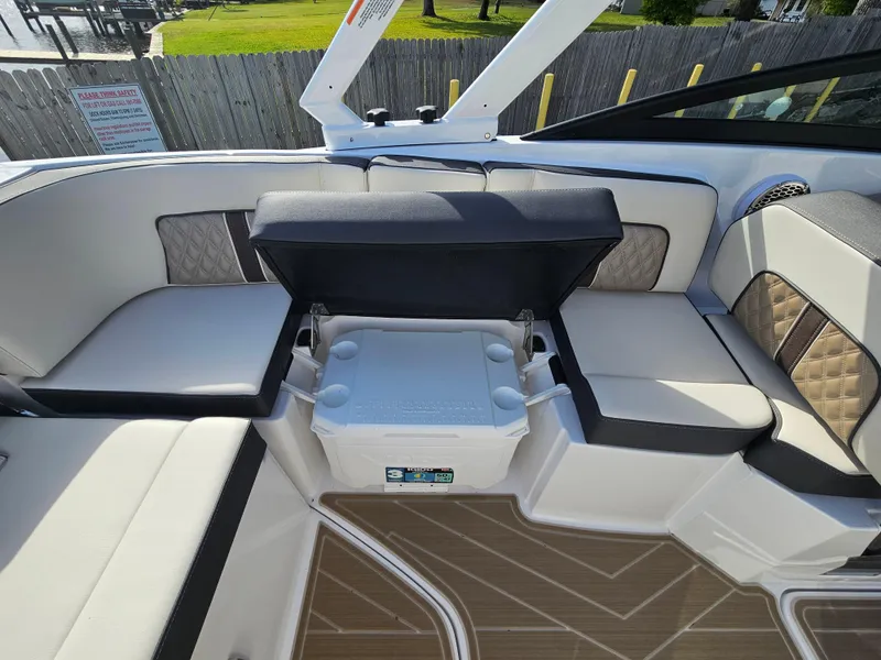 Slide: The Image of 2025 Monterey M-65 boat interior with cushioned seating and built-in cooler on deck. - 18