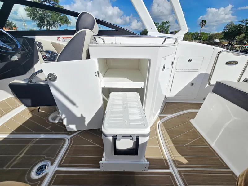 Slide: The Image of Interior of 2025 Monterey M-65 boat with open storage compartment and cooler. - 24