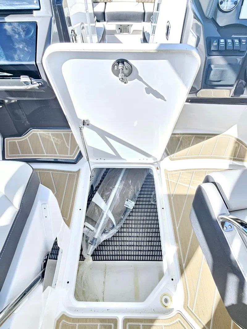 Slide: The Image of 2025 Monterey M-65 boat interior with open storage compartment and modern seating. - 26