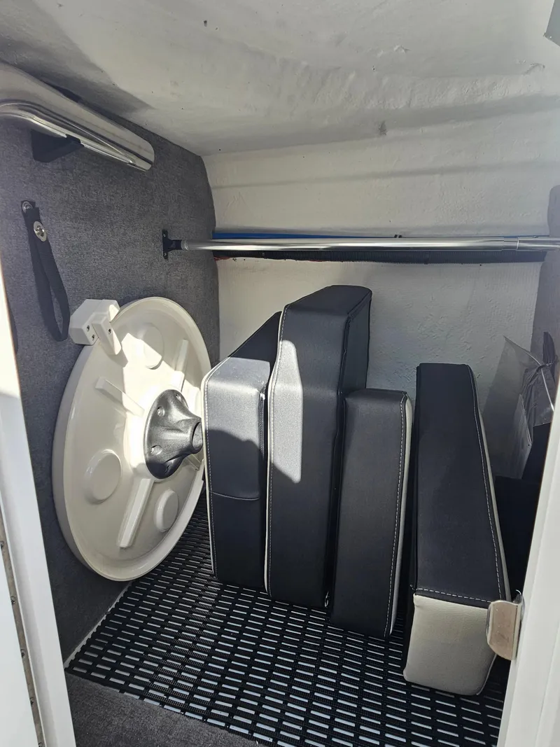 Slide: The Image of Storage compartment in a 2025 Monterey M-65 boat with cushions and a life preserver. - 31