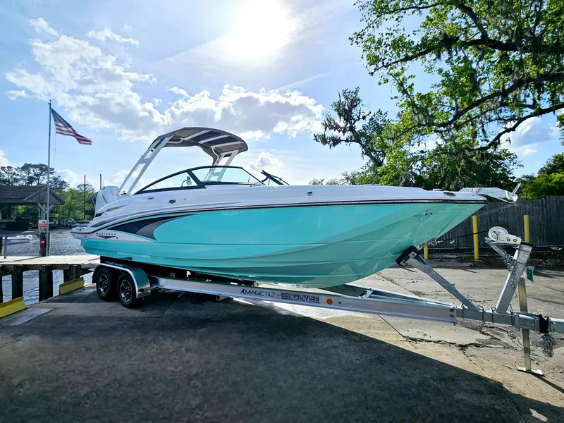 Slide: The Image of 2025 Monterey M-65 boat on trailer, sunny day, American flag, trees in background. - 5