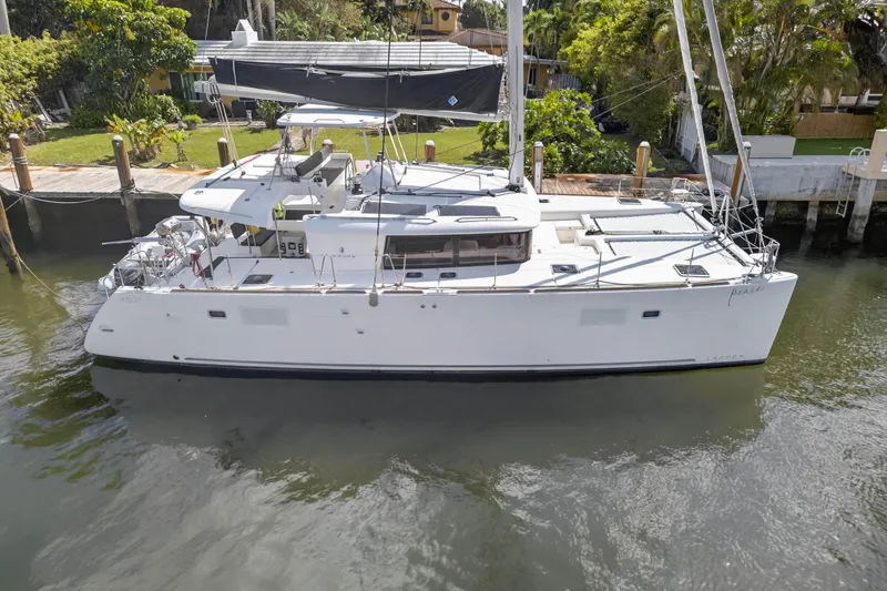 The Image of 2019 Lagoon 450 F catamaran docked in a serene marina setting. - 0
