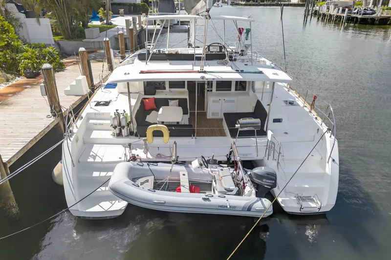 Slide: The Image of 2019 Lagoon 450 F catamaran docked with inflatable boat, spacious deck, and seating area. - 11