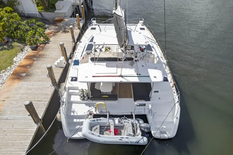 Slide: The Image of Aerial view of 2019 Lagoon 450 F catamaran docked with tender boat attached. - 12
