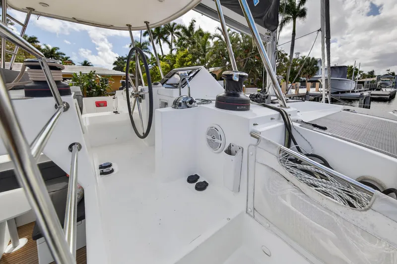 Slide: The Image of 2019 Lagoon 450 F yacht cockpit with steering wheel and winch, docked near palm trees. - 15