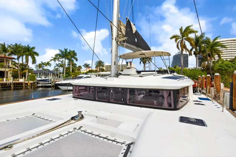 Slide: The Image of 2019 Lagoon 450 F catamaran docked, surrounded by palm trees and clear blue sky. - 26