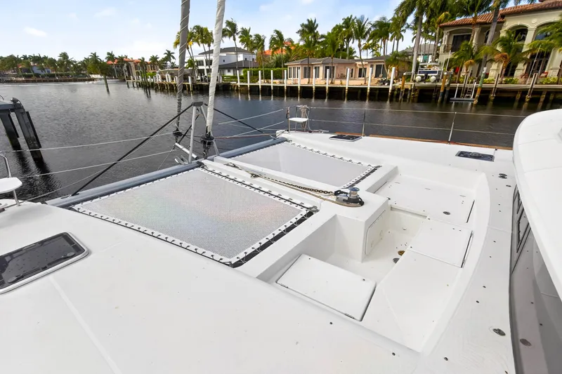 Slide: The Image of 2019 Lagoon 450 F catamaran deck with waterfront view and palm trees. - 28