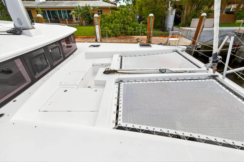 Slide: The Image of 2019 Lagoon 450 F catamaran deck with netting and dockside view. - 29