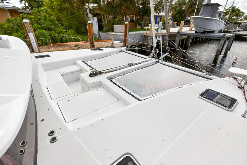 Slide: The Image of 2019 Lagoon 450 F catamaran deck with storage compartments and dock view. - 31