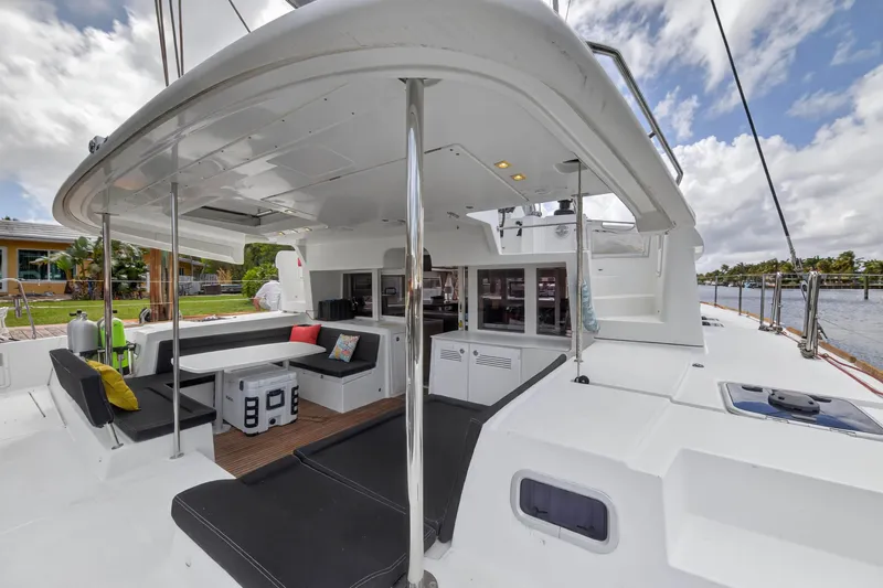 Slide: The Image of 2019 Lagoon 450 F catamaran deck with seating, table, and open cabin view. - 35