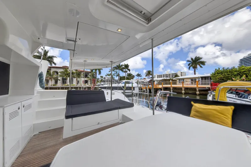 Slide: The Image of 2019 Lagoon 450 F yacht interior with seating, table, and marina view. - 40