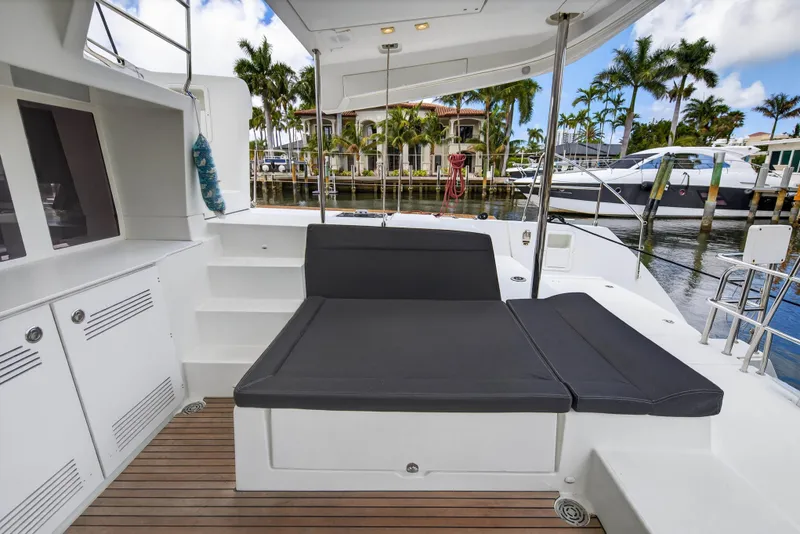 Slide: The Image of 2019 Lagoon 450 F yacht deck with seating, docked near palm trees and luxury boats. - 41