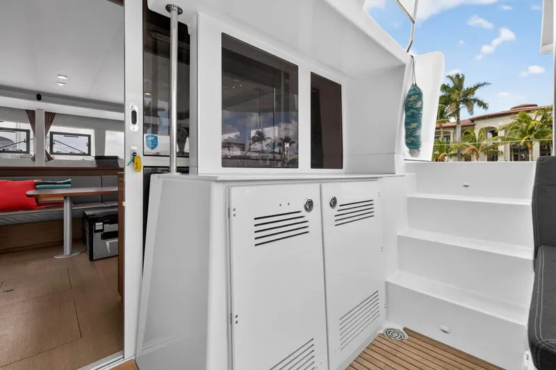 Slide: The Image of 2019 Lagoon 450 F yacht interior with modern design, featuring seating and steps, tropical backdrop. - 46