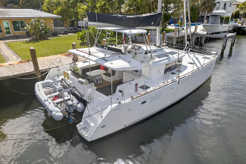 Slide: The Image of 2019 Lagoon 450 F catamaran docked, featuring spacious deck and modern design. - 5