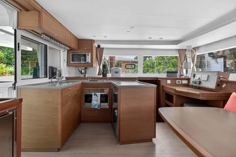 Slide: The Image of Modern kitchen interior of 2019 Lagoon 450 F catamaran with wood cabinetry and appliances. - 58