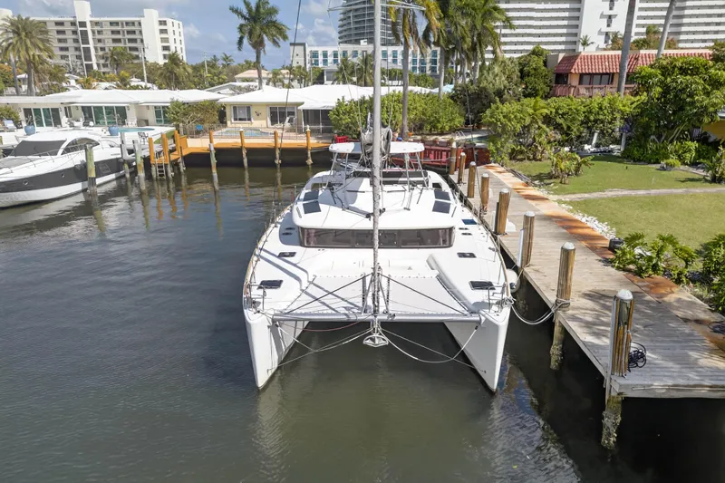Slide: The Image of 2019 Lagoon 450 F catamaran docked in a scenic marina with palm trees. - 6
