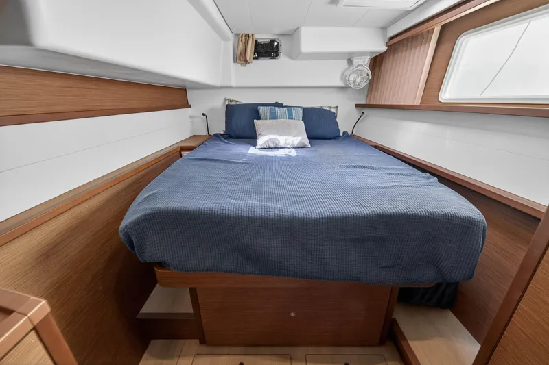Slide: The Image of 2019 Lagoon 450 F cabin interior with cozy bed and wooden accents. - 76
