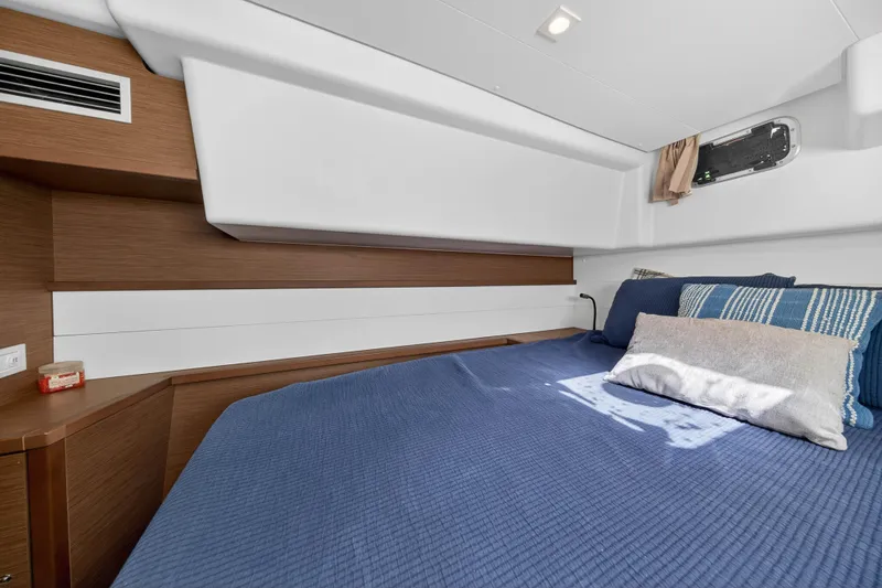 Slide: The Image of Cozy cabin interior of 2019 Lagoon 450 F yacht with blue bedding and wooden accents. - 77