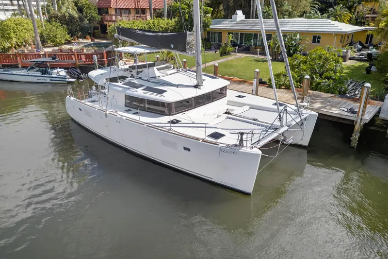 Slide: The Image of 2019 Lagoon 450 F catamaran docked by a waterfront property. - 9