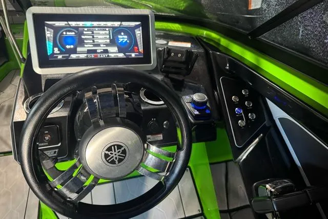 Slide: The Image of 2022 Yamaha Boats 255XD dashboard with steering wheel and digital display, featuring vibrant green accents. - 2