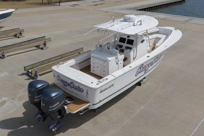 Slide: The Image of 2018 Regulator 31 boat with twin Yamaha engines on a concrete dock. - 12