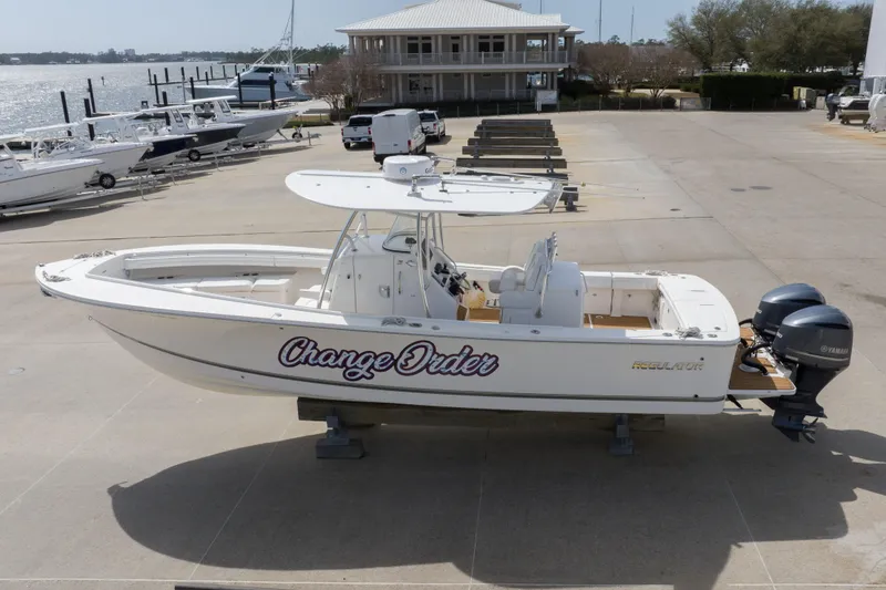Slide: The Image of 2018 Regulator 31 boat with twin Yamaha engines, docked near waterfront. - 15