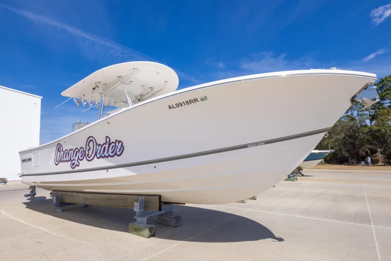 Slide: The Image of 2018 Regulator 31 boat named "Change Order" on display under clear blue sky. - 2