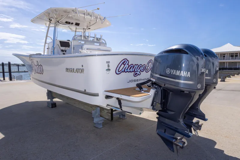Slide: The Image of 2018 Regulator 31 boat with twin Yamaha 300 engines docked by the water. - 21