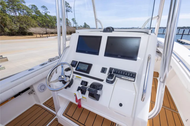 Slide: The Image of 2018 Regulator 31 boat helm with dual screens and modern controls. - 29