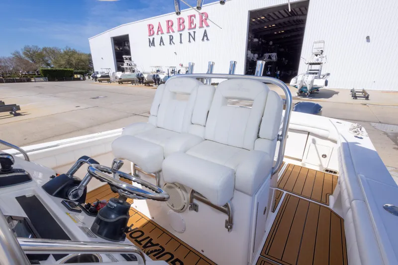 Slide: The Image of 2018 Regulator 31 boat interior at Barber Marina, featuring dual white captain's chairs. - 34