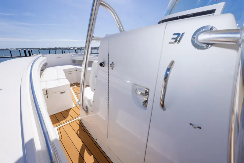Slide: The Image of 2018 Regulator 31 boat interior with white seating and wooden deck. - 37