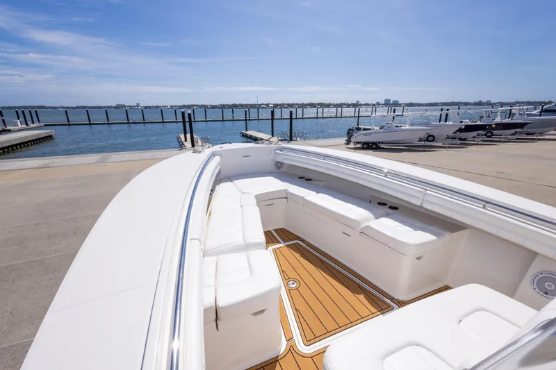 Slide: The Image of 2018 Regulator 31 boat with spacious seating, docked by a scenic waterfront. - 38
