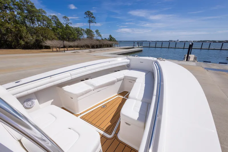 Slide: The Image of 2018 Regulator 31 boat with spacious seating, docked by a scenic waterfront. - 39