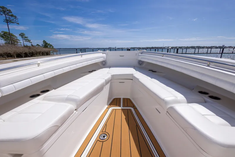 Slide: The Image of 2018 Regulator 31 boat with spacious white seating and wooden deck, docked by the water. - 40