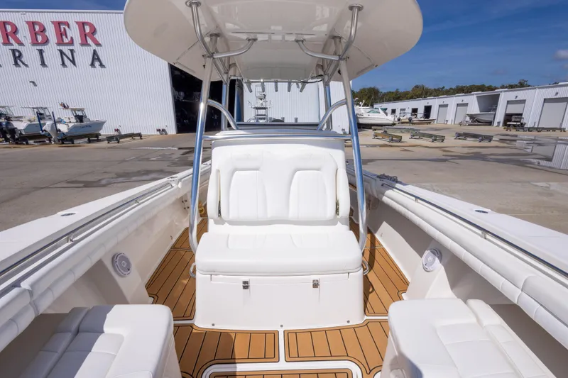 Slide: The Image of 2018 Regulator 31 boat interior with white seating and wooden deck at a marina. - 42